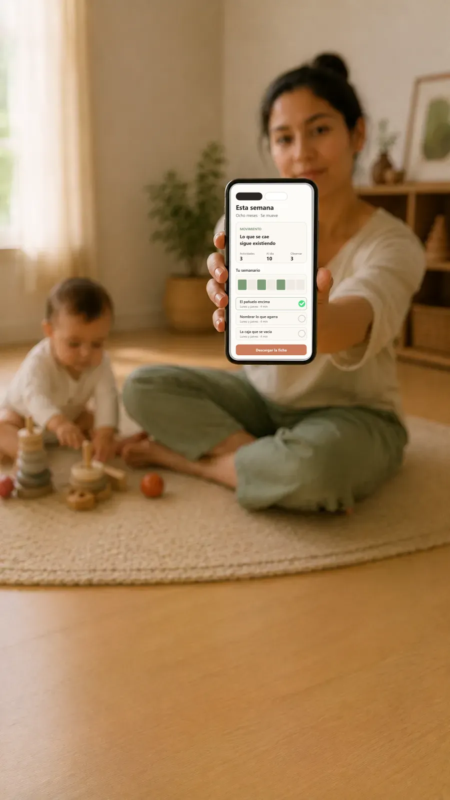 Una madre con su bebé, mirando en el celular las actividades de la semana